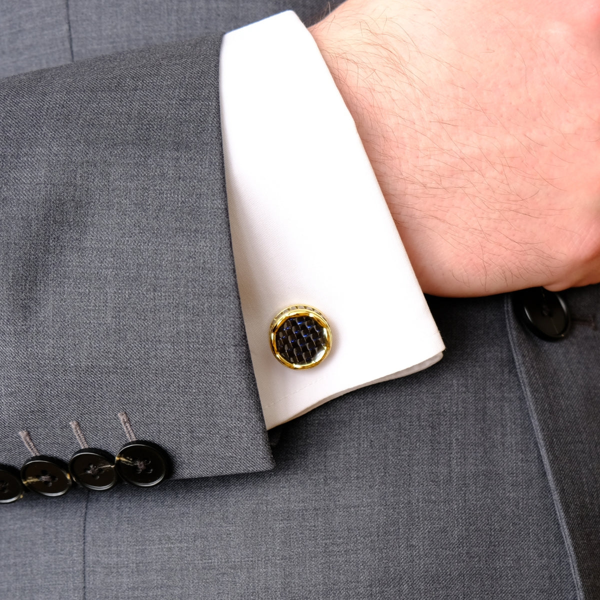 Close-up of a gray suit with a gold cufflinks SKADIS Jewelry