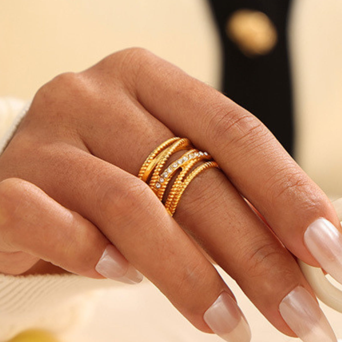 A hand wearing multiple gold rings - SKADIS Jewelry