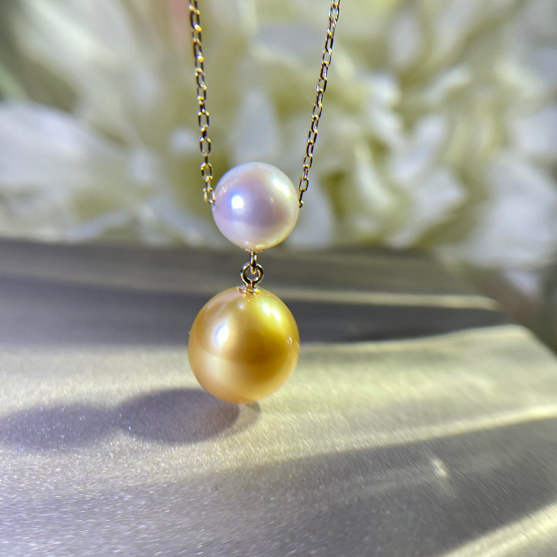 Necklace in 18k Gold adorned with Akoya and Southsea gold pearl on light background