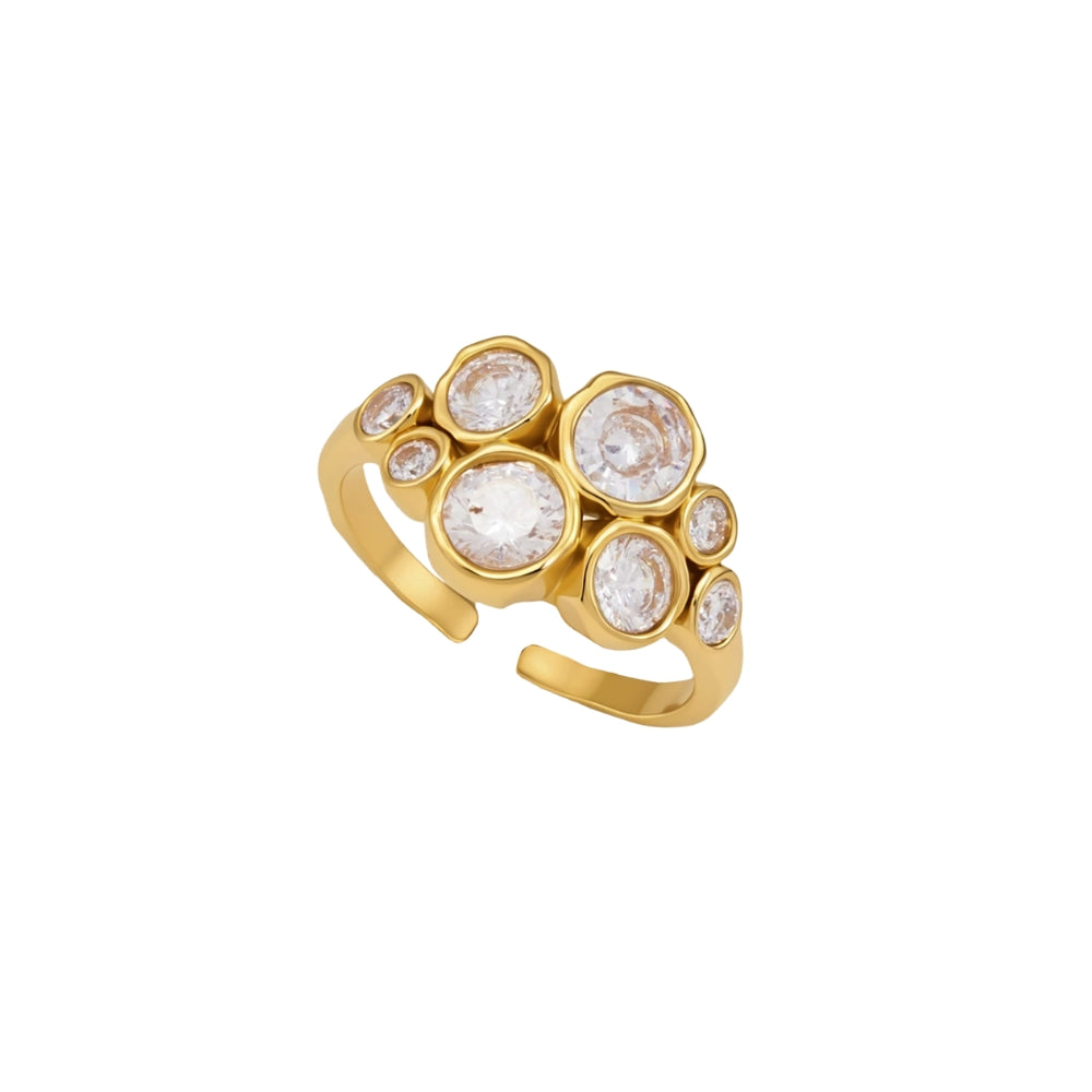 A gold adjustable ring featuring a cluster of bezel-set zirconia in various sizes