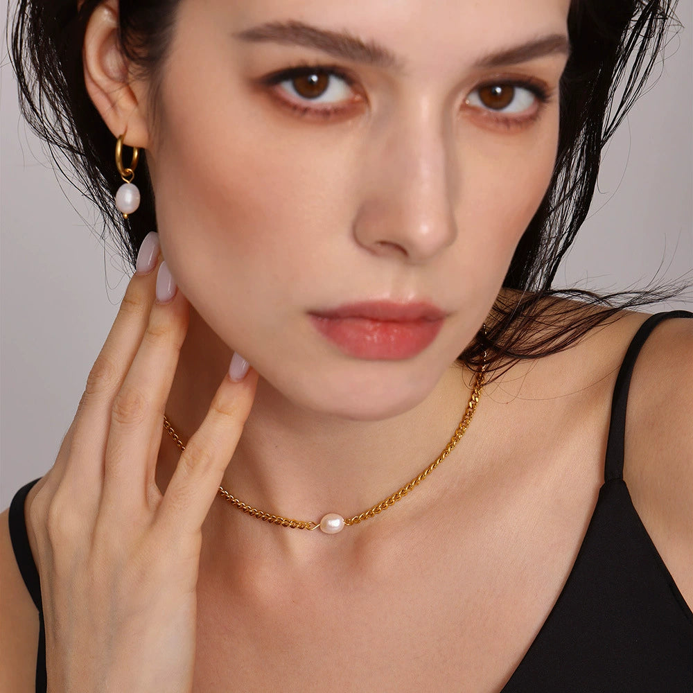 Woman wearing a gold necklace with pearl