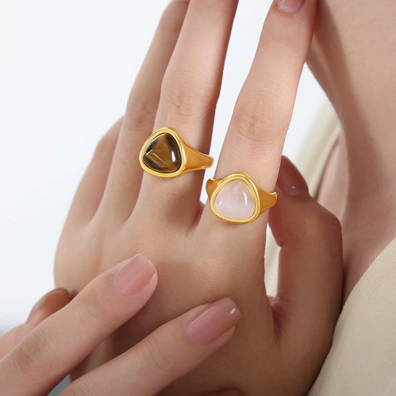 Gold rings with heart-shaped gemstones on a hand SKADIS Jewelry