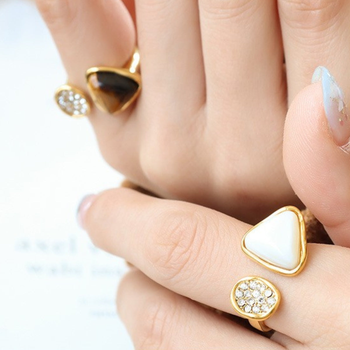 Hand wearing gold rings with seashell -SKADIS Jewelry