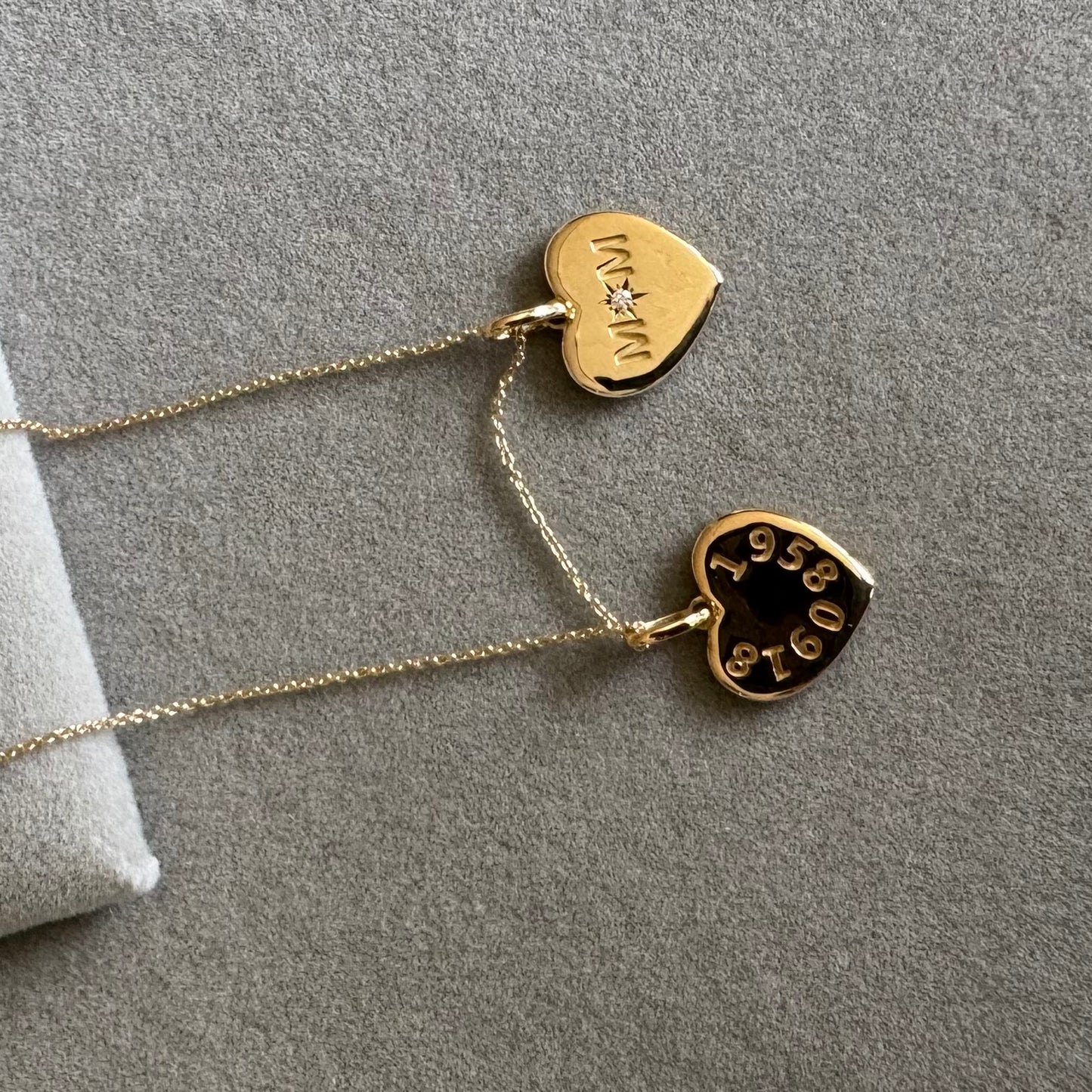 A gold-toned necklace with two dangling heart charms from SKADIS Jewelry