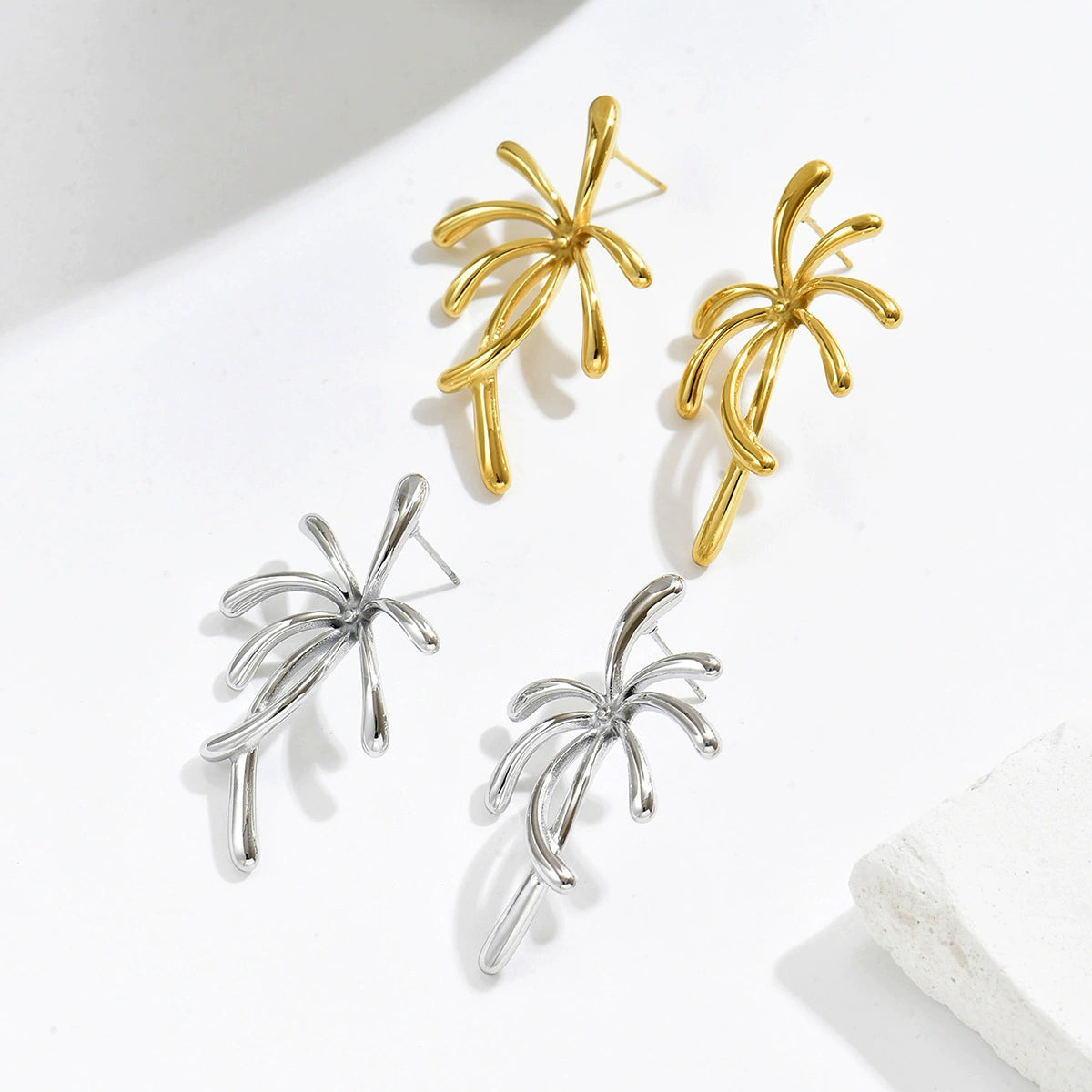 Gold and silver palm tree-shaped earrings from SKADIS Jewelry