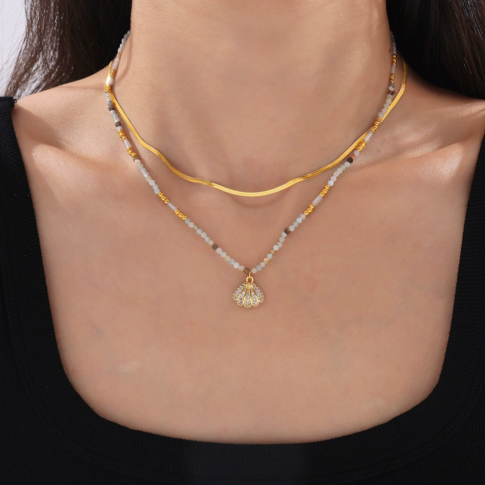 Gold necklace with a pendant on a model from SKADIS Jewelry