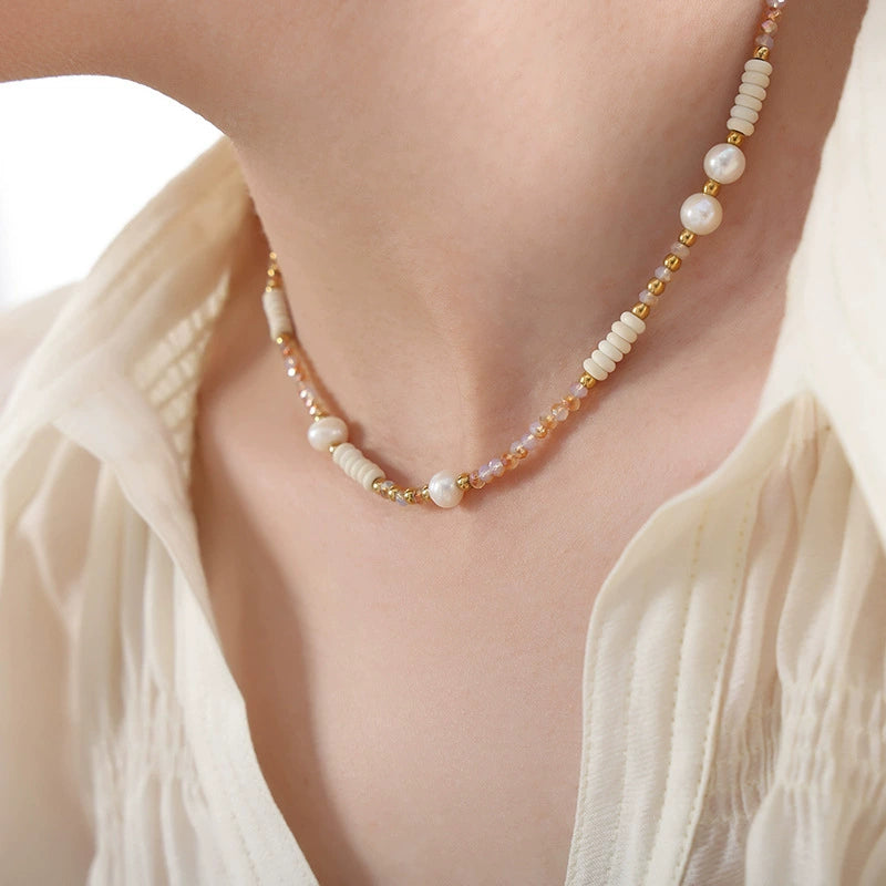 Pearl necklace with gold accents worn by a person from SKADIS Jewelry