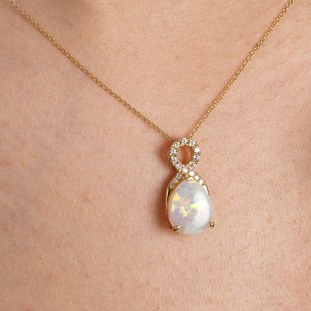 Opal pendant necklace on a gold chain worn by a person
