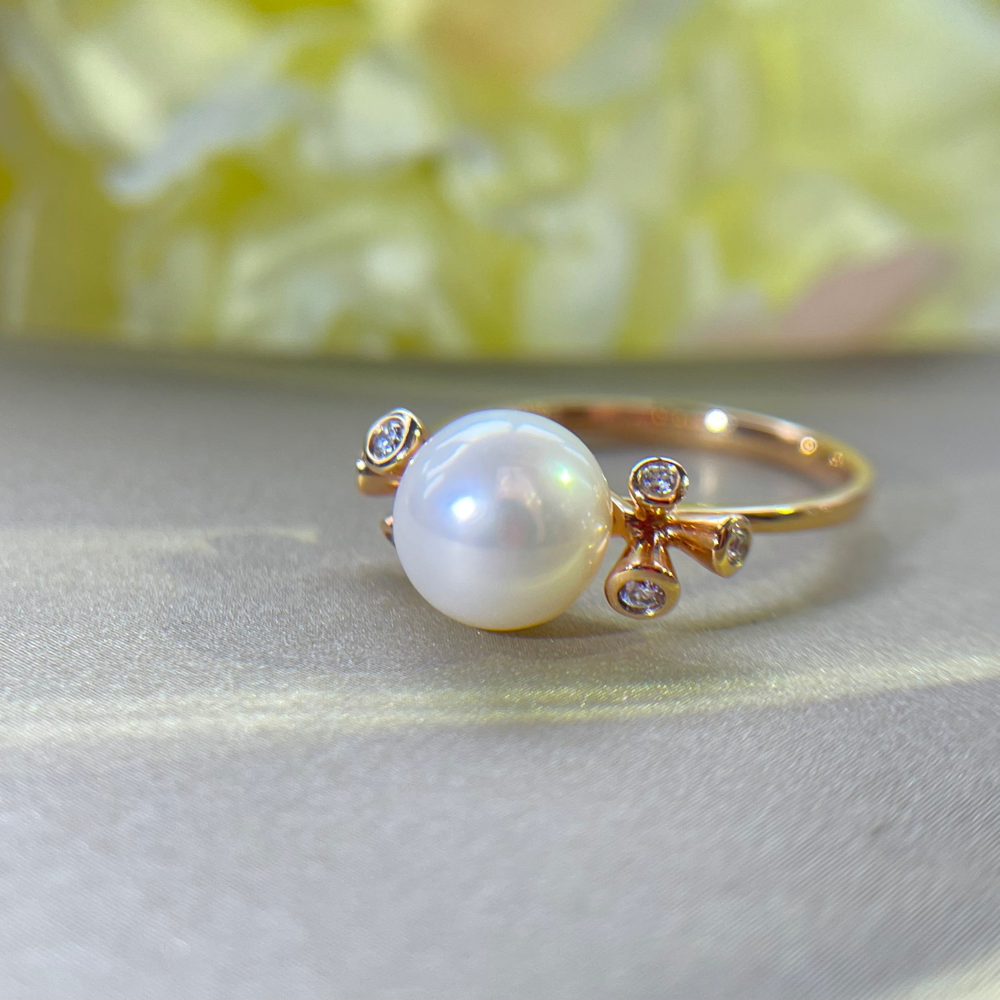 Pearl ring with gold accents on a light fabric background
