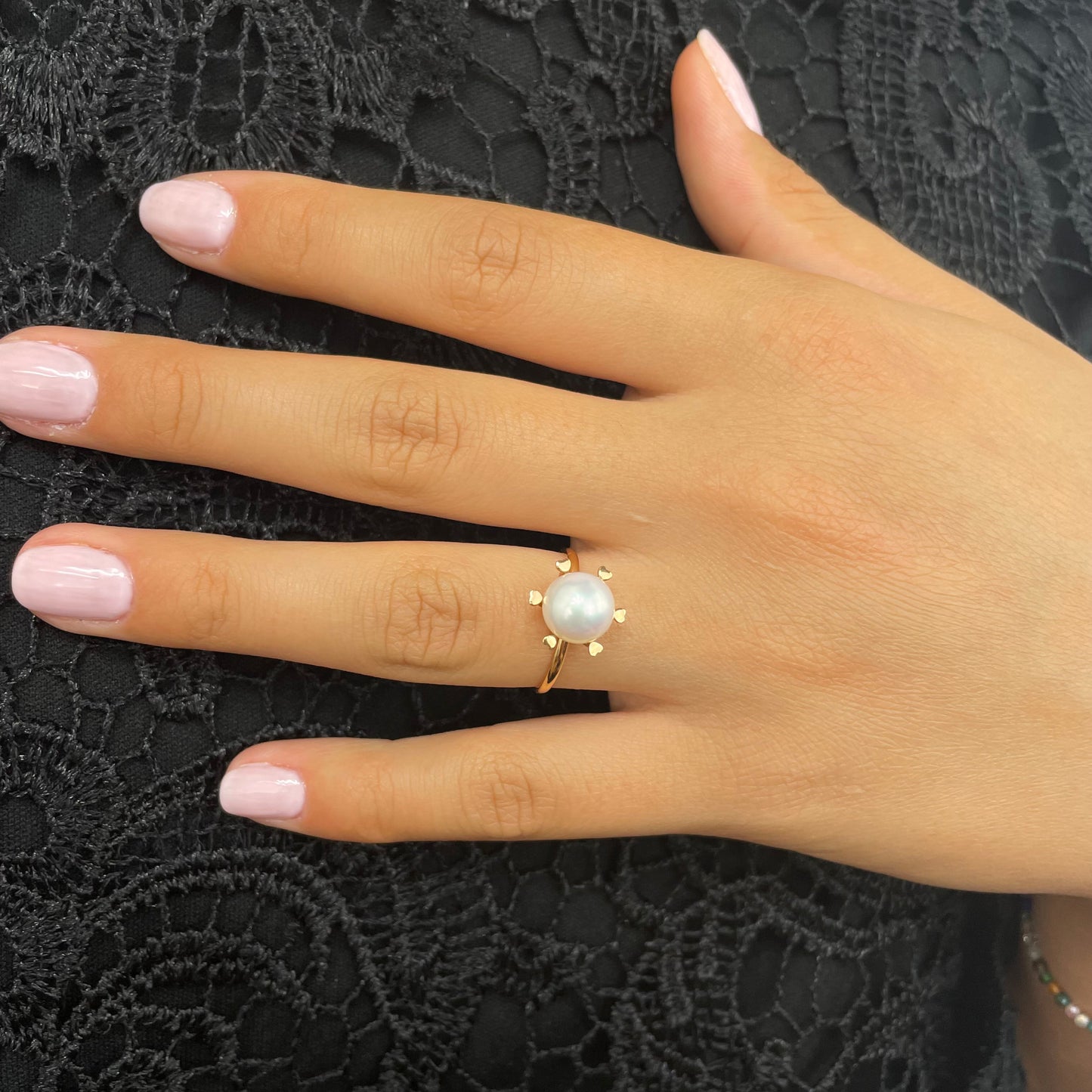Hand wearing a AKOYA pearl ring on a black lace clothes