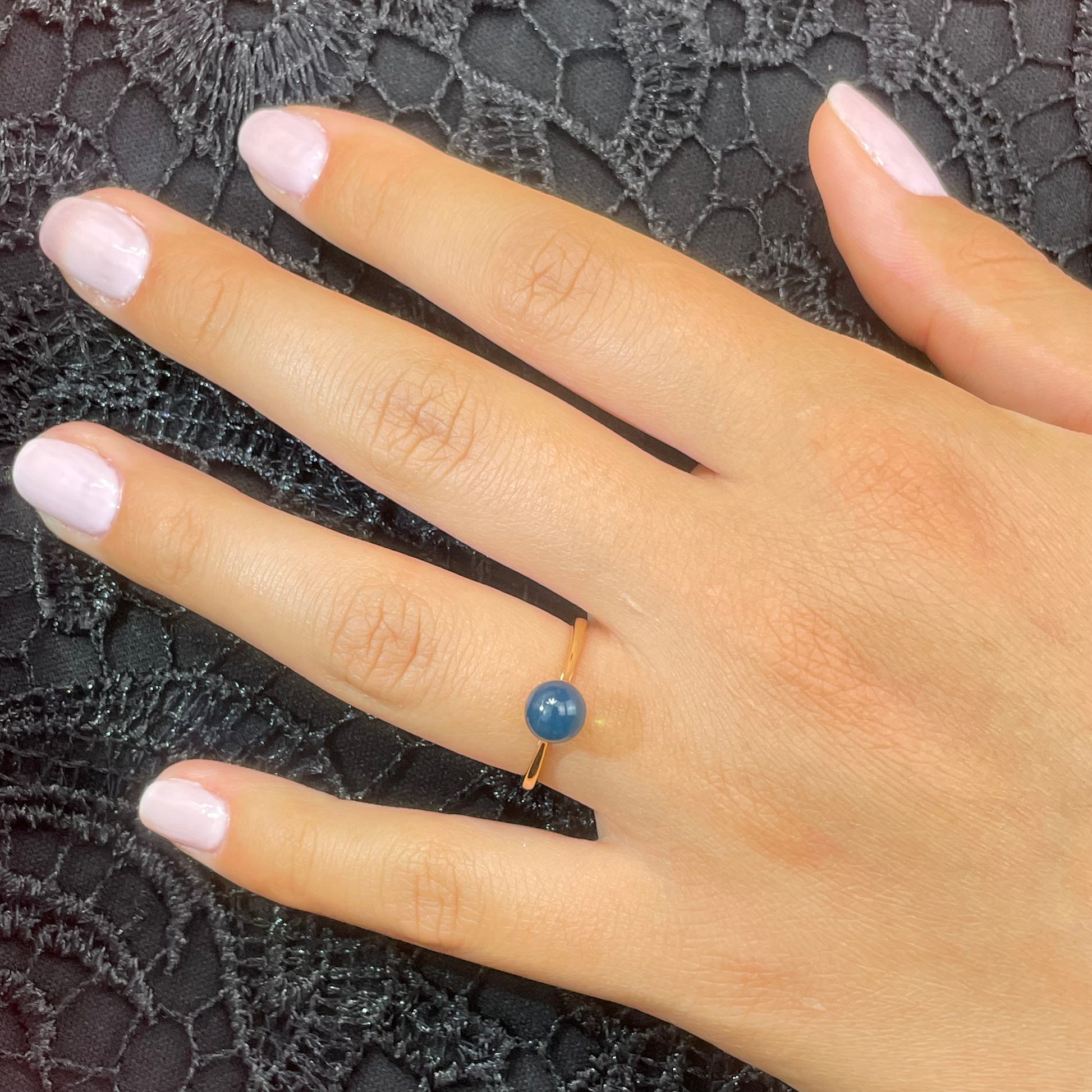 A model wearing natural blue amber ring in 18k gold from SKADIS Jewelry Copenhagen.