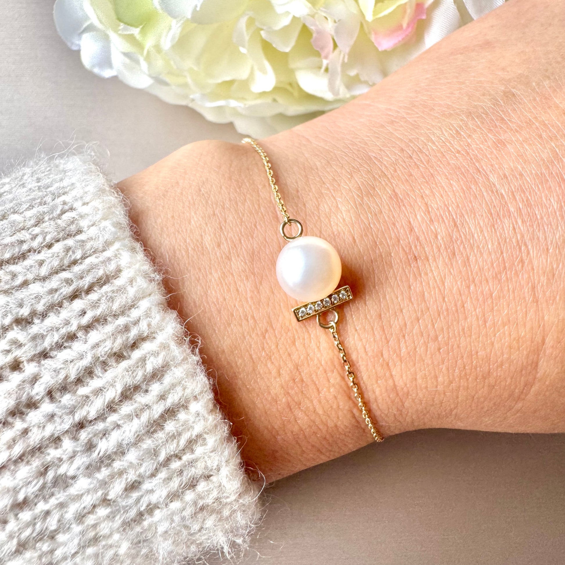 Pearl bracelet on a wrist with a soft background.