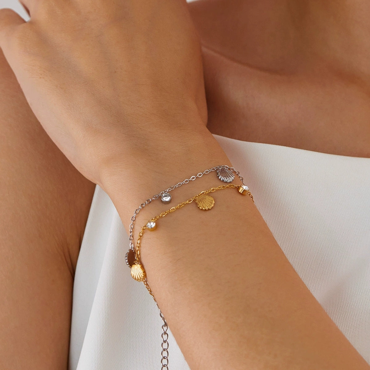 A model wearing a gold-plated and silver bracelet from SKADIS Jewelry