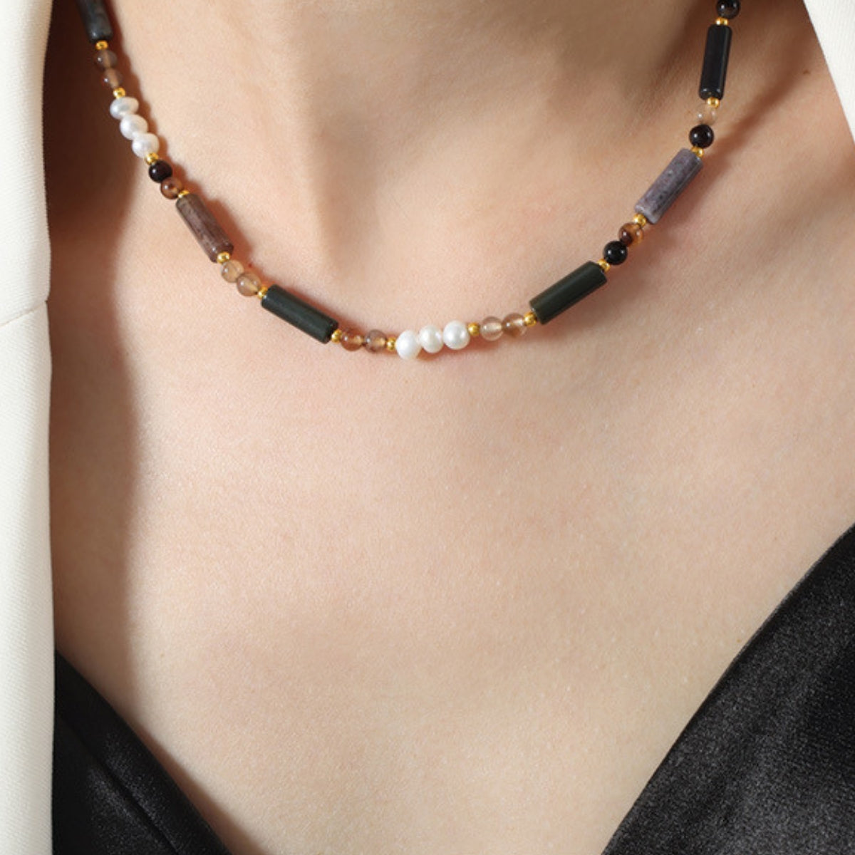 Necklace with beads on a person wearing a black top - SKADIS Jewelry