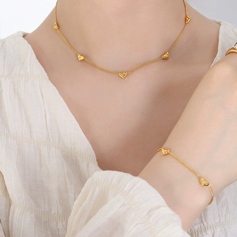 Gold necklace and bracelet on a person from SKADIS Jewelry