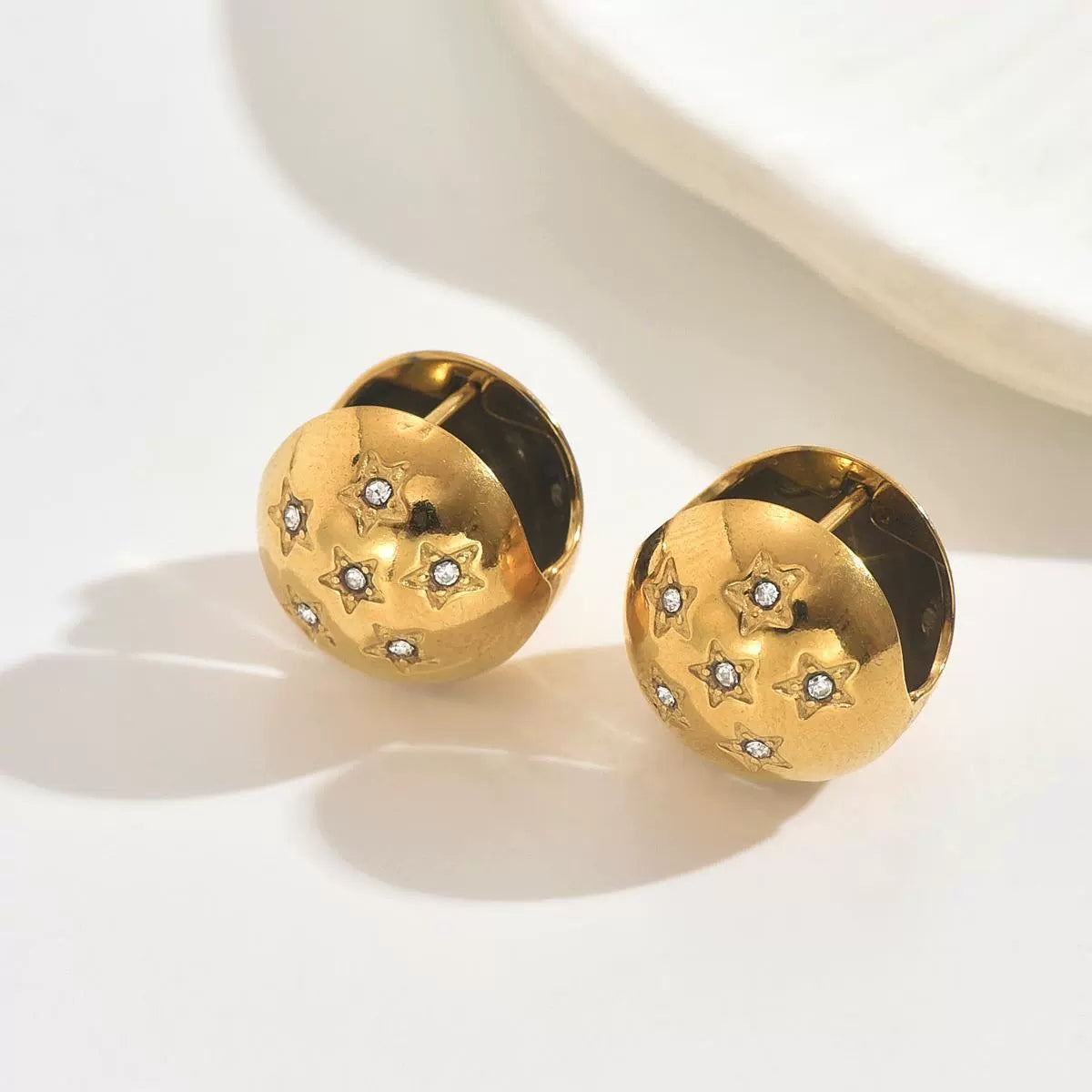 Gold earrings with star designs from SKADIS Jewelry
