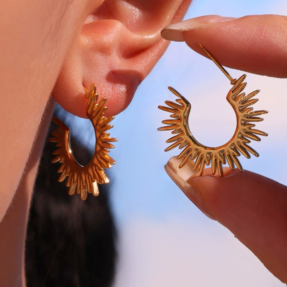 Gold hoop earrings being worn by a model - SKADIS Jewelry