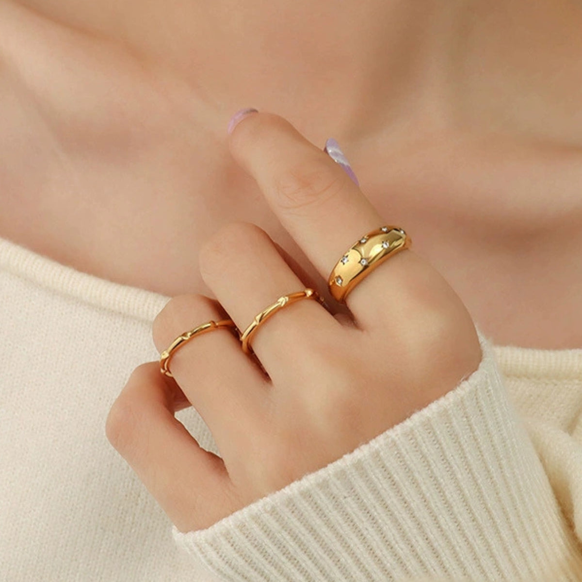 Gold rings on a person's fingers from SKADIS Jewelry