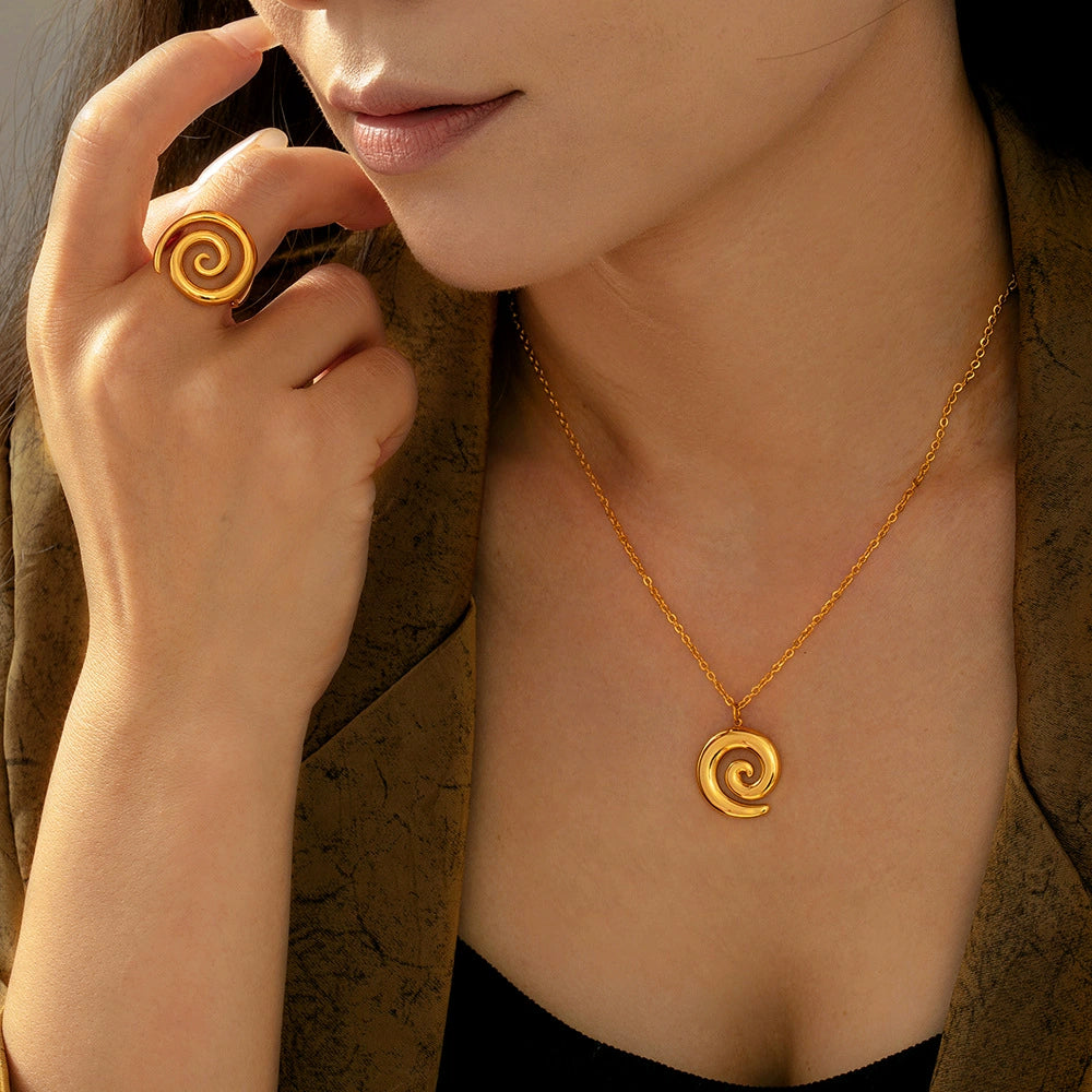 a person wearing a gold spiral necklace and ring from SKADIS Jewelry