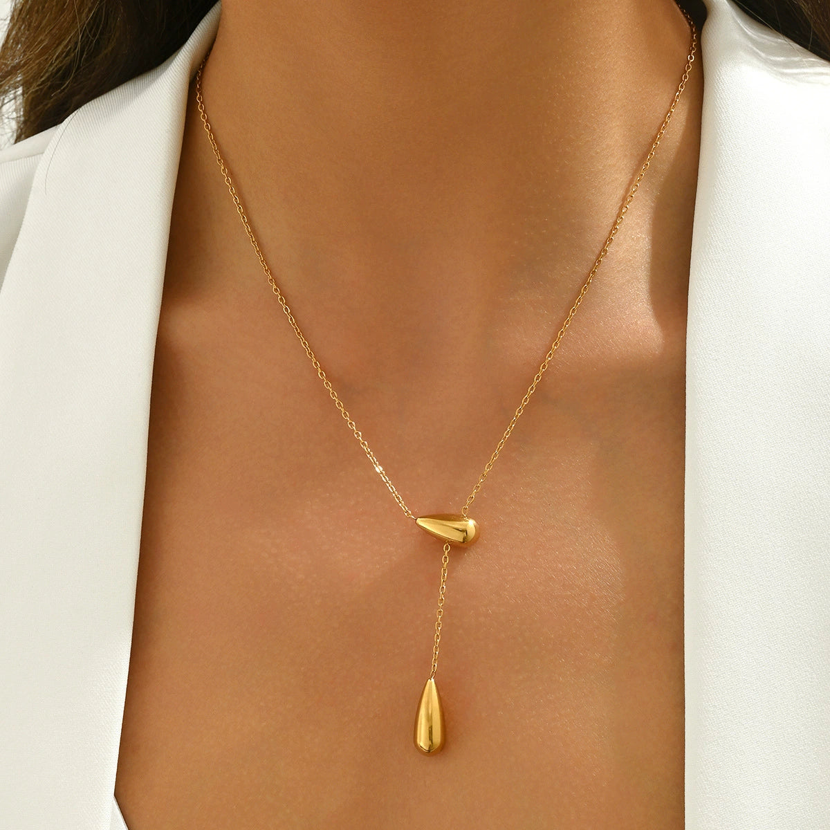 Gold necklace with a drop pendant on a person from SKADIS Jewelry