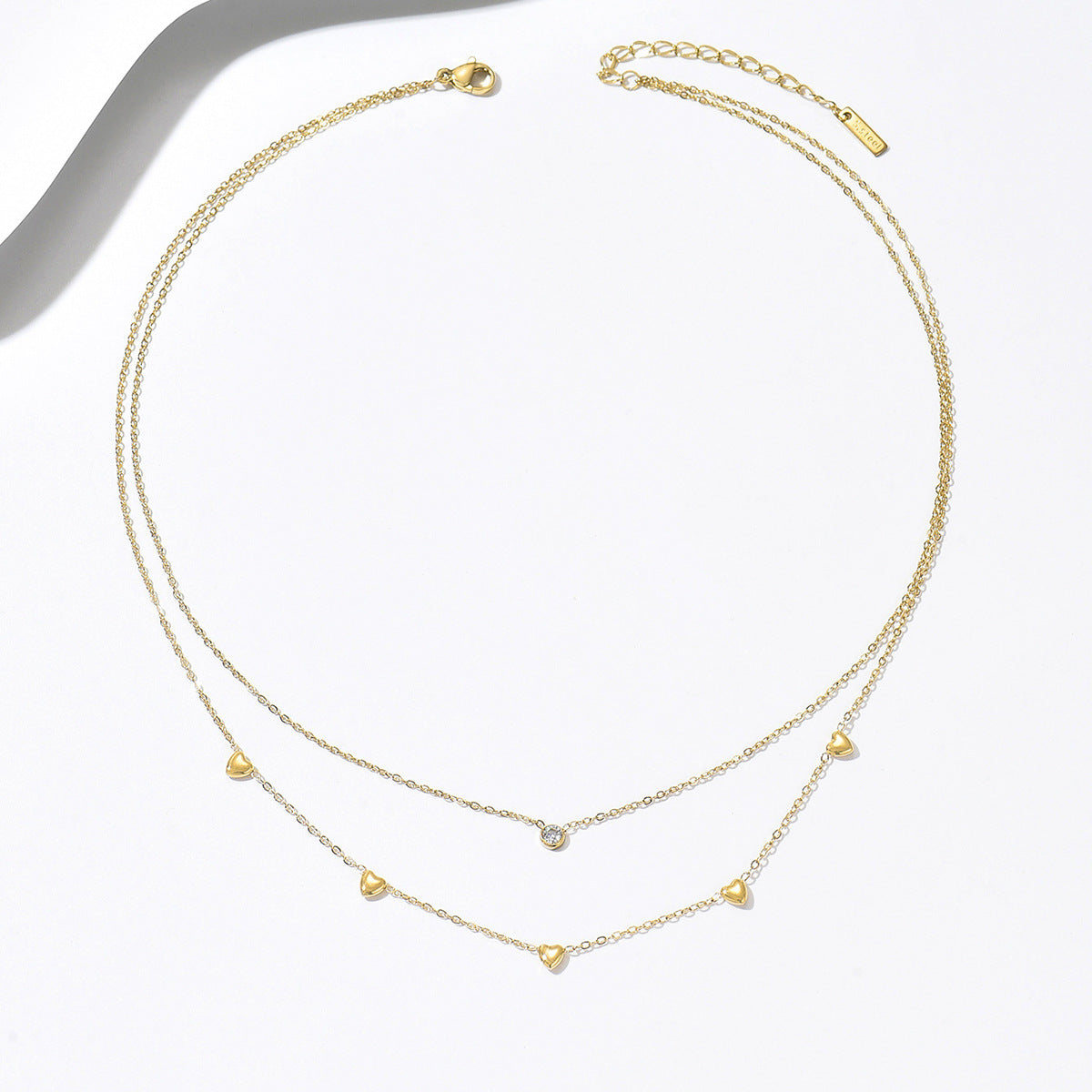 Two gold necklaces with small heart pendants from SKADIS Jewelry